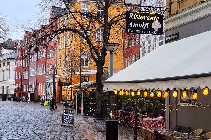Charming street in Old Copenhagen with colorful buildings and a cozy Italian restaurant, ideal for exploring hidden gems.