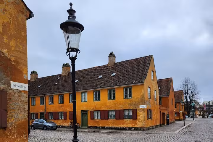 Historic yellow houses and a vintage street lamp in a quiet corner of Old Copenhagen's charming neighborhood.