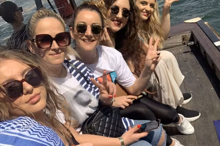 Tour guests enjoy an abra boat ride on Dubai Creek during Old Dubai local food tasting walking tour