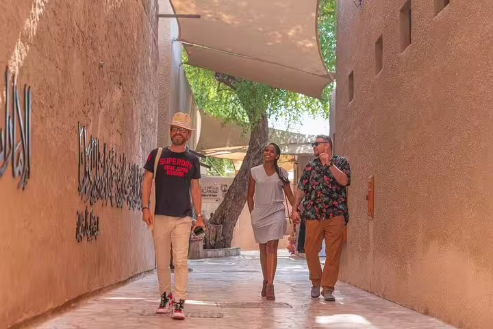 Small group enjoying a guided walking tour through shaded alleys of Al Fahidi historic district in Old Dubai
