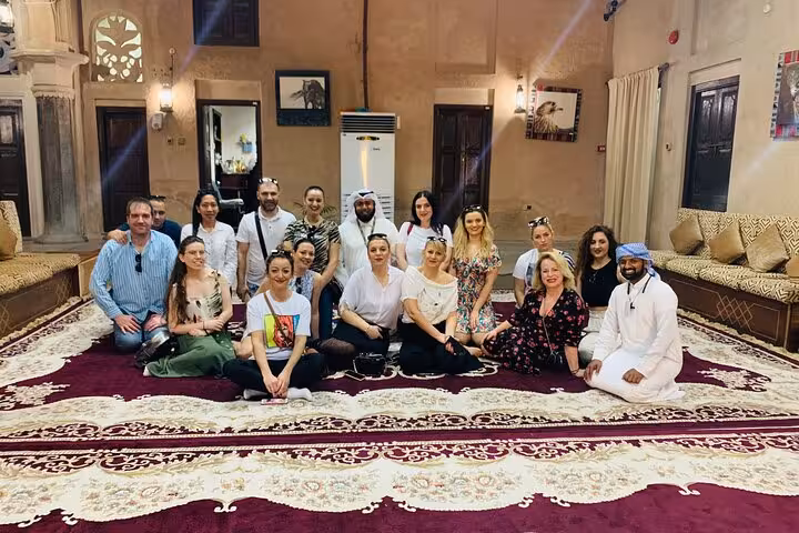 Small group seated in a heritage house majlis during a half-day Old Dubai historic and cultural walking tour