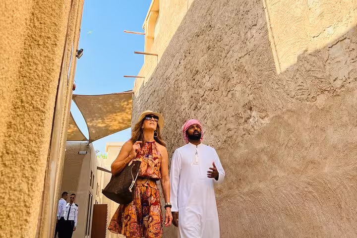 Tour guide leads travelers through Al Fahidi alleyways on a half-day Old Dubai historic walking tour