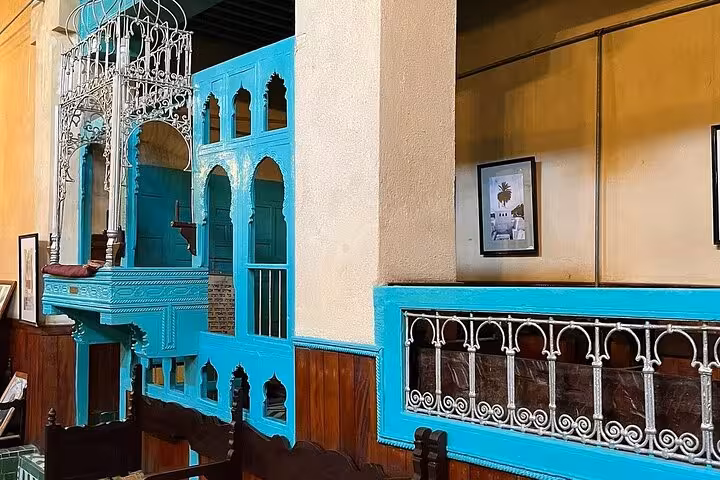 Vibrant blue and white traditional Moroccan architecture in Old Medina Fez, showcasing intricate wooden latticework.