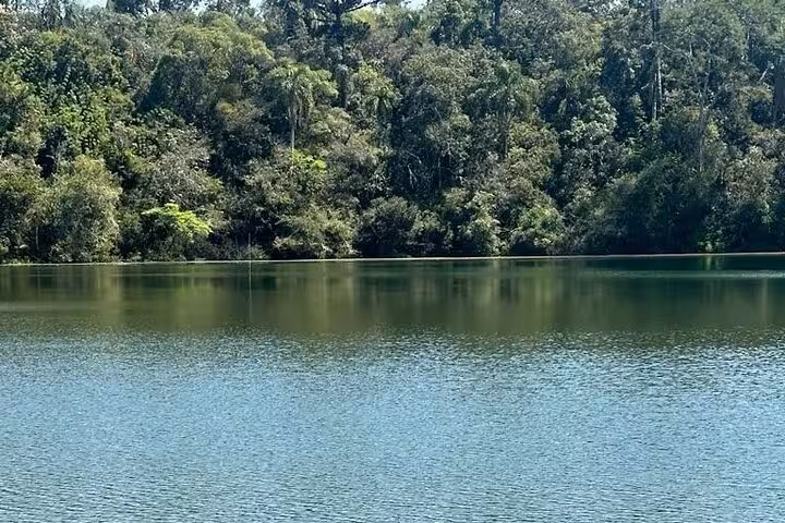 Tranquil lake surrounded by lush greenery at Old Town State Park's Hole of the Father, perfect for a serene escape.