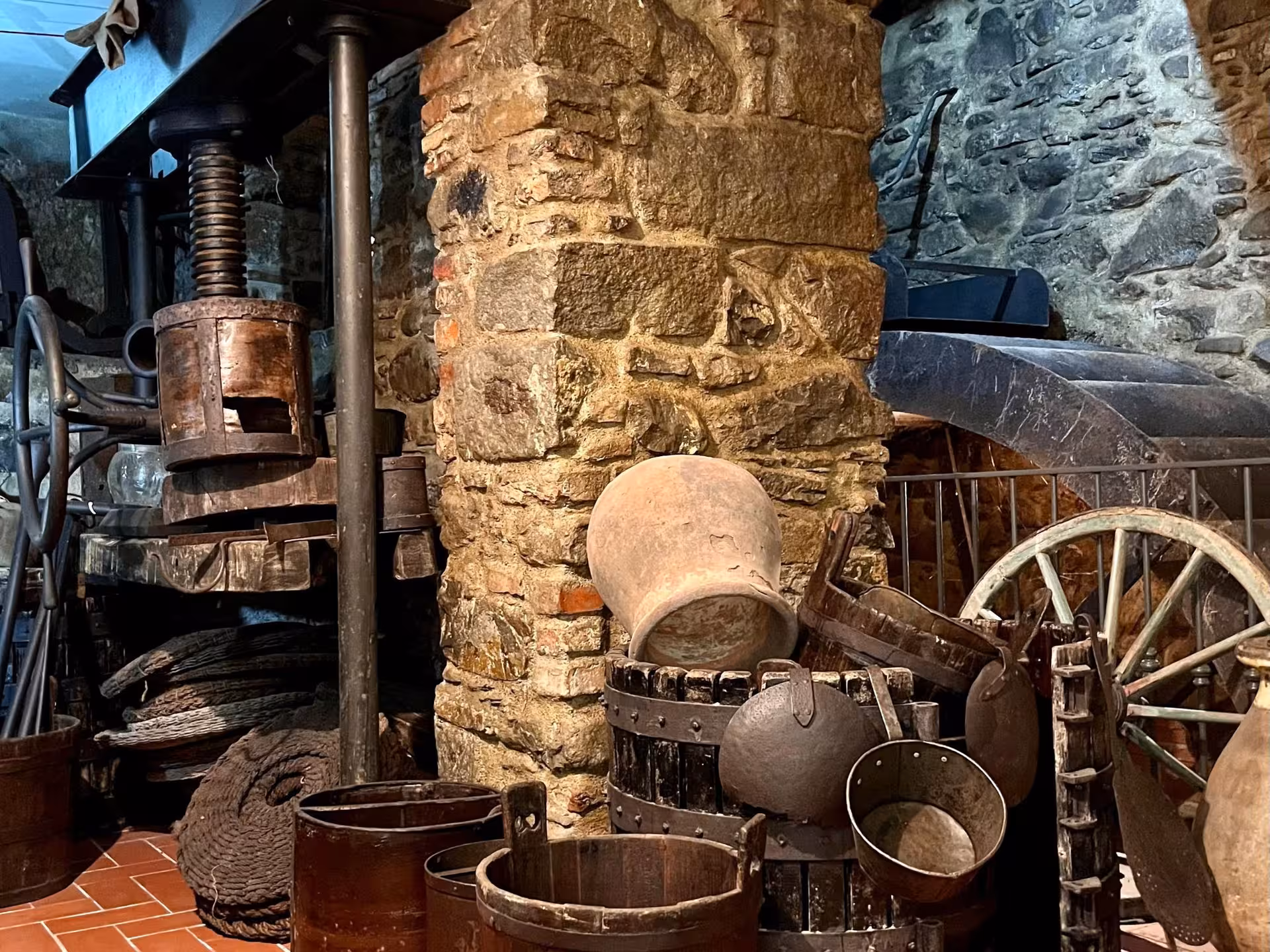 Historical olive press and vintage tools in a Taggia mill, offering a glimpse into traditional oil-making methods.