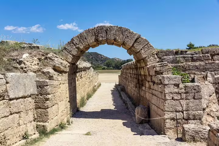 Ancient stone archway entrance at Olympia archaeological site, Greece, on a full-day guided tour