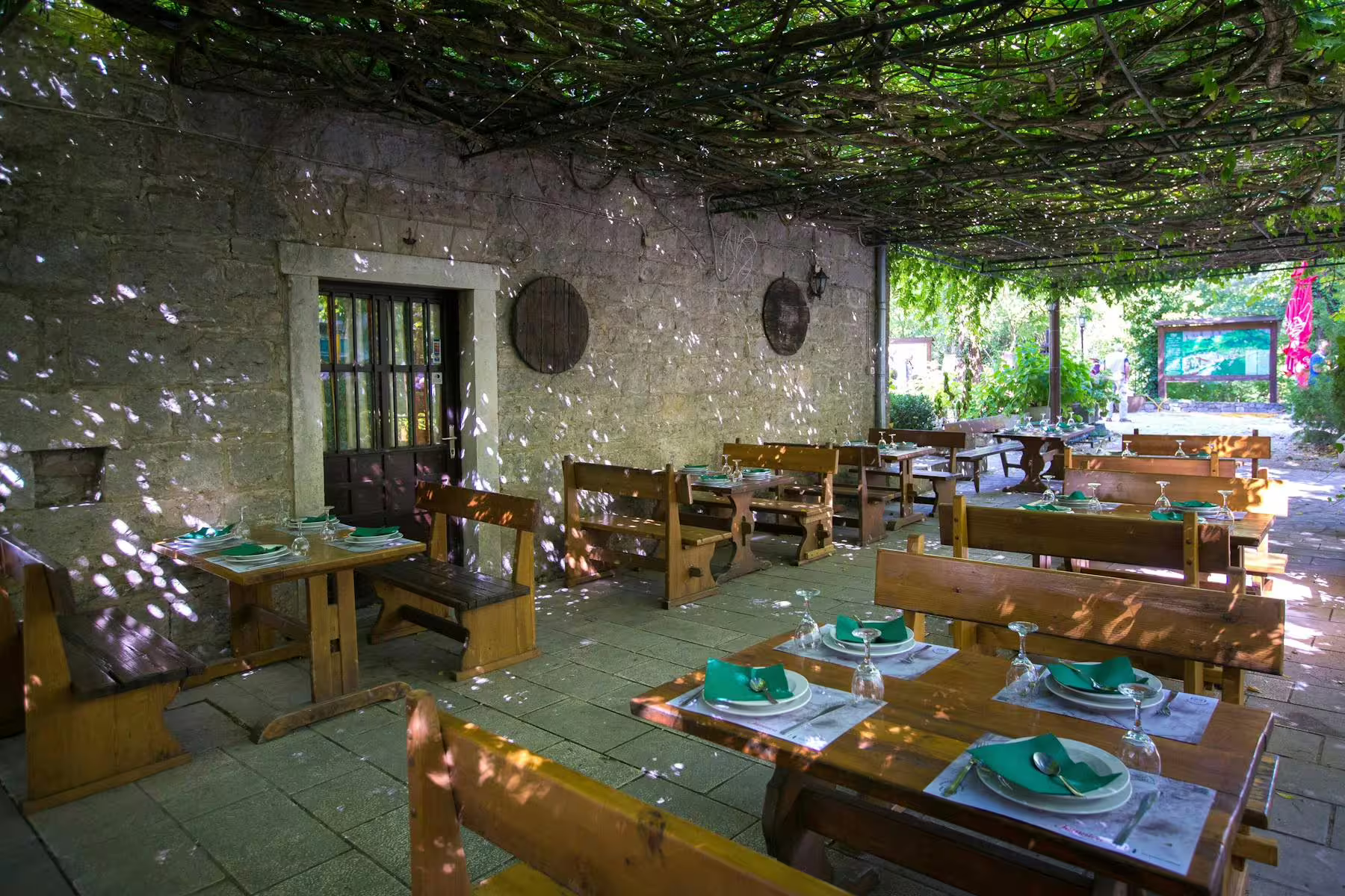 Rustic riverside restaurant terrace set for included lunch on Omiš and River Cetina boat tour from Makarska