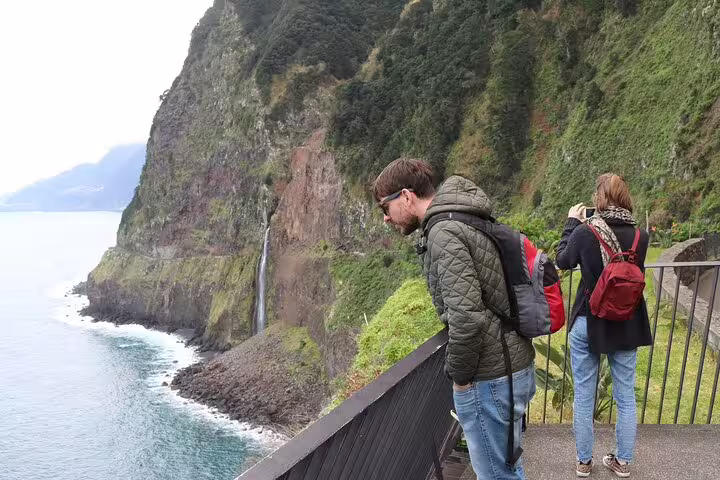 Tourists enjoy breathtaking coastal cliffs and waterfalls in Madeira's northwest on an open-roof 4x4 adventure.