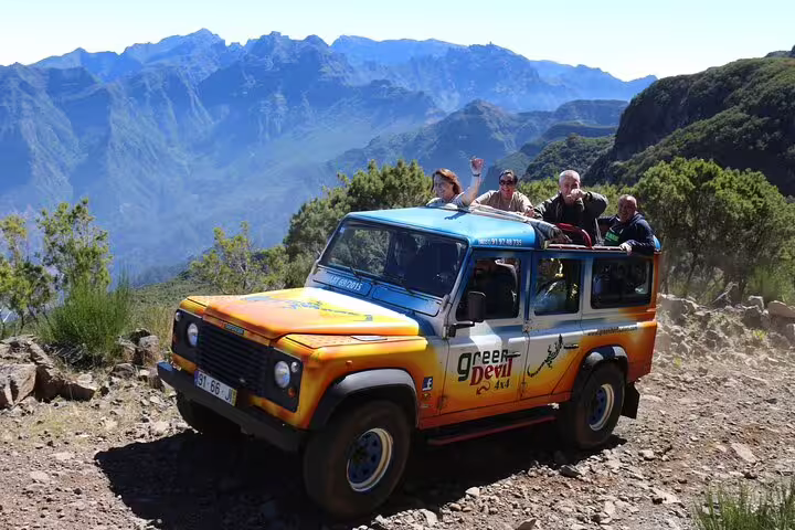 Group enjoying a scenic open-roof 4x4 adventure in the stunning mountainous terrain of northwest Madeira.