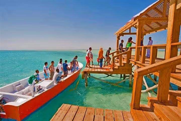 Guests disembark boat onto Orange Bay Gifton Island pier, Hurghada snorkeling tour on crystal Red Sea