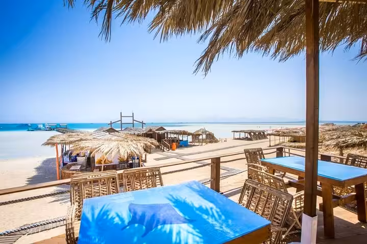 Orange Bay Island beach bar with shaded huts and sea view, VIP boat trip from Hurghada Red Sea