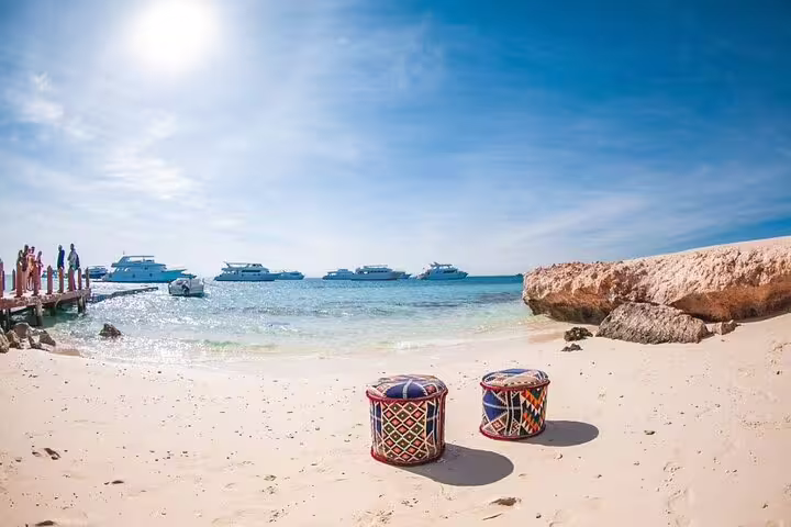 Sandy Orange Bay Island beach with sea view and boats offshore, VIP snorkeling day trip from Hurghada