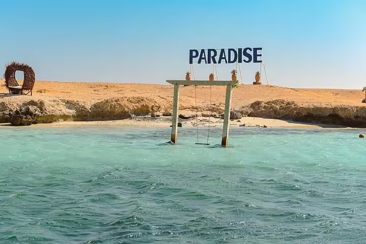 Turquoise lagoon and Paradise sign at Orange Bay Island, a stop on Hurghada VIP snorkeling boat tour