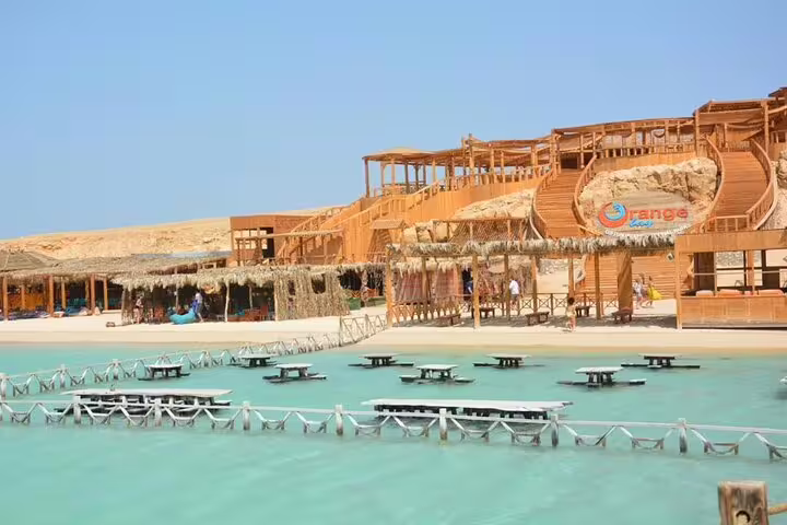 Orange Bay Island beach club and wooden terraces over turquoise lagoon, VIP boat trip from Hurghada