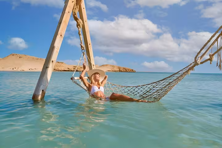 Relaxing in sea hammock at Orange Bay Hurghada, Red Sea island day trip with snorkeling, lunch and drinks