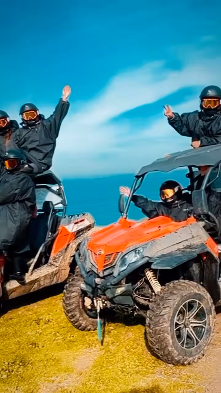 Close-up of orange off-road buggy with riders on a cliffside viewpoint on the Dust Breaker Buggy Tour by the sea