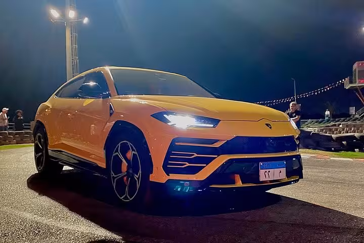 Orange super SUV on the AUTOVROOOM circuit at night, highlighting the exciting karting experience track