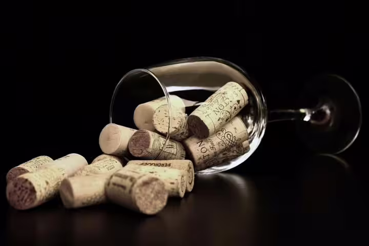 Close-up of wine corks spilling from a glass, highlighting the elegance of organic wineries on a private tour.
