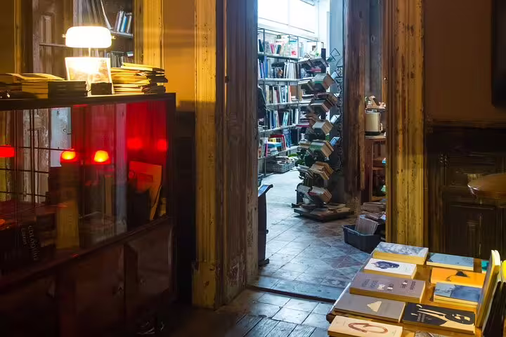 Cozy, dimly-lit bookstore interior with shelves of books, creating an inviting ambiance for a natural wine tasting and pairing experience.