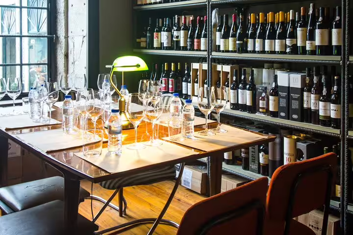 Cozy wine tasting setup with organic bottles and glasses on a wooden table, perfect for a natural wine and food pairing experience.