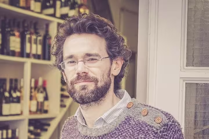 Wine expert standing in a Nice wine shop, surrounded by a selection of organic wines.