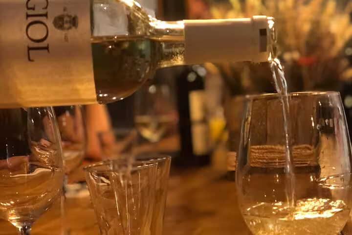White wine being poured into glasses during an organic wine tasting event in Nice, creating a warm, inviting atmosphere.