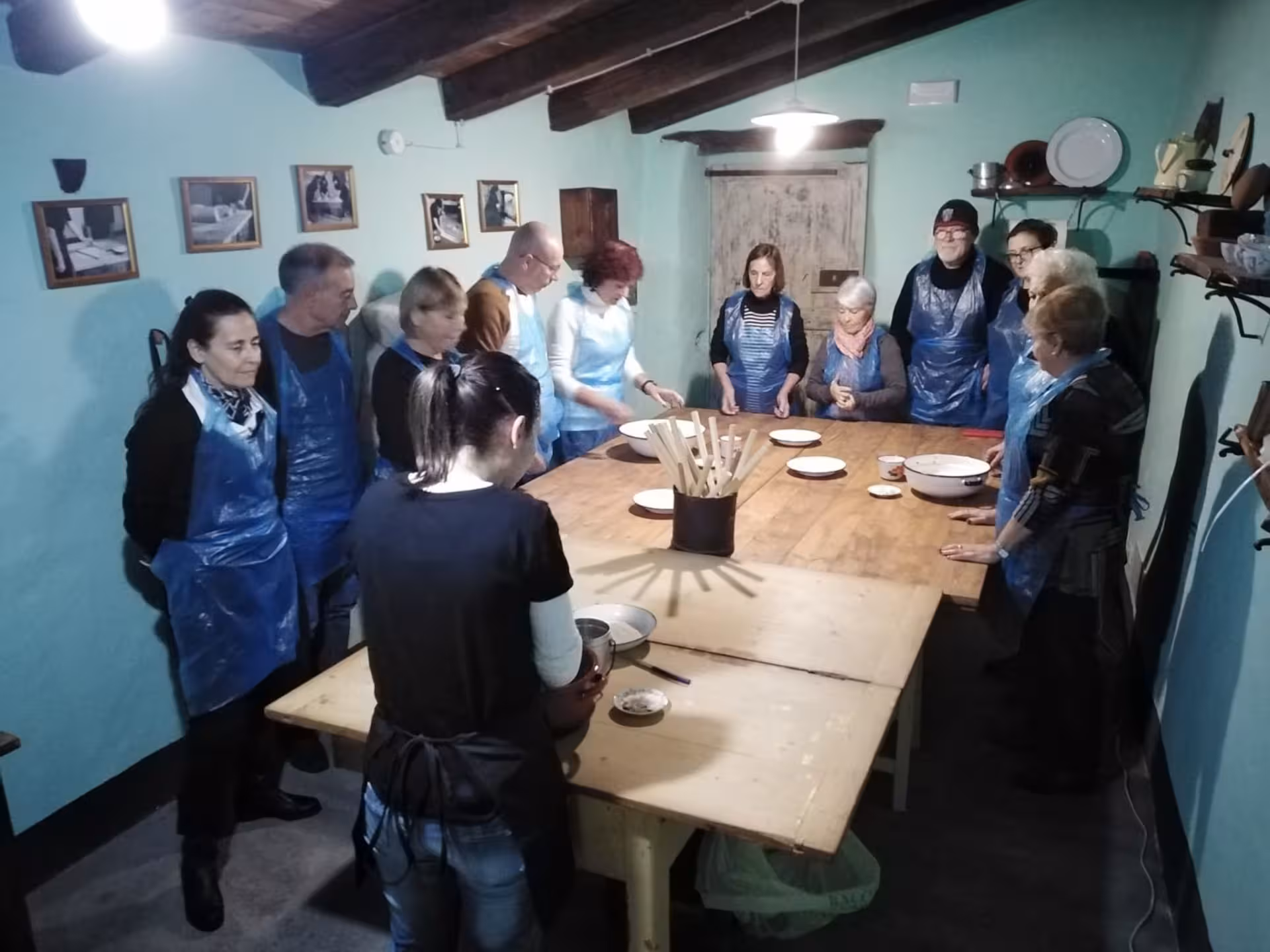 Participants gather around a table in Orgosolo for a hands-on carasau bread workshop experience.