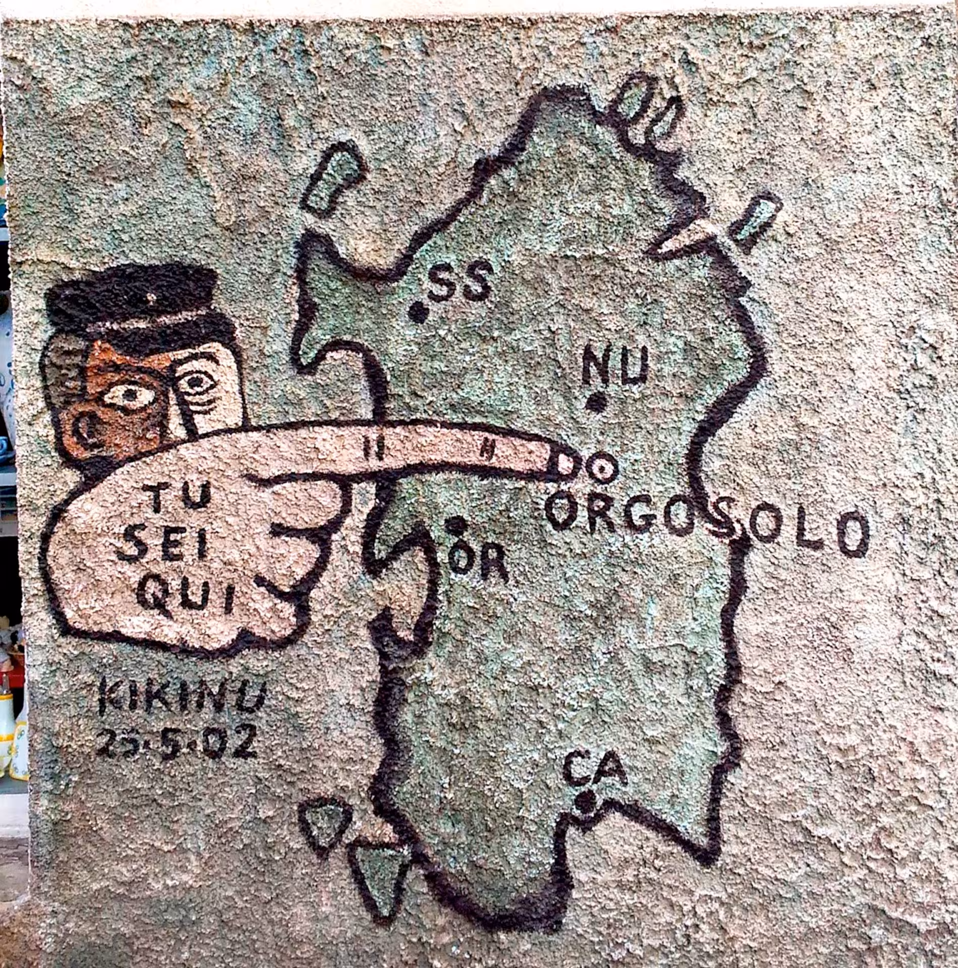 Colorful mural in Orgosolo depicting a map of Sardinia with a pointing figure, highlighting the location of Orgosolo.
