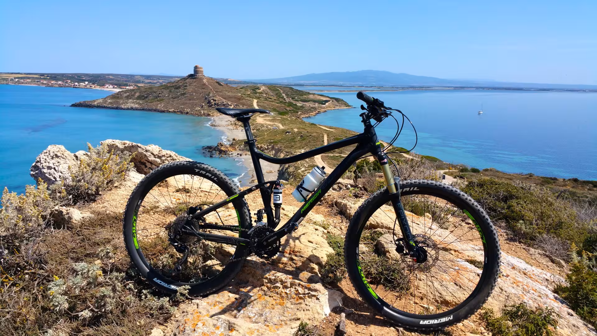 Bicycle overlooking the stunning coastal landscape and ancient tower on the Sinis Peninsula bike tour.