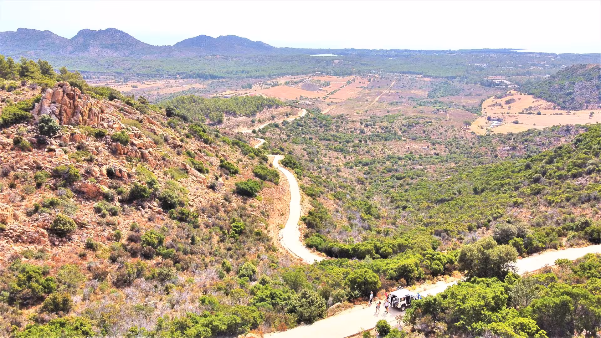 Aerial view of winding road through Capo Comino's rugged terrain, ideal for private jeep tours from Orosei.