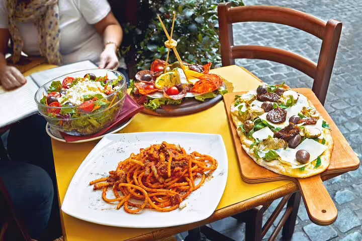 Authentic Italian lunch with pasta, salad, and pizza served on an outdoor table during Orvieto private guided tour from Rome.
