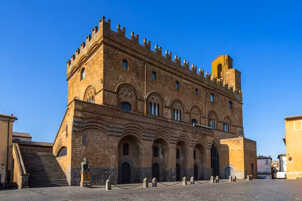 Explore Orvieto's majestic medieval architecture under a clear blue sky in Umbria's heart.