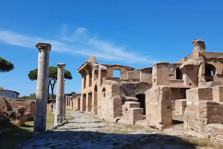 Ruins of ancient Roman structures with standing columns under a clear blue sky in Ostia Antica.
