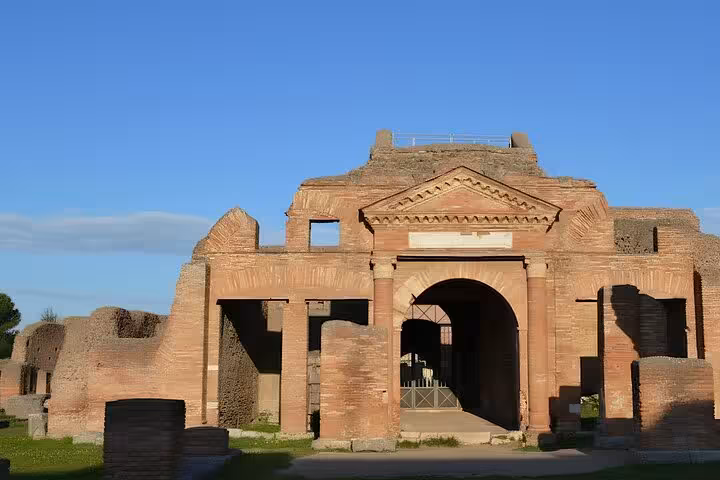 Explore the ancient ruins of Ostia Antica on a half-day private tour, featuring its impressive Roman architecture against a clear blue sky.