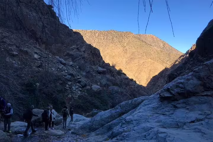 Hikers trekking rocky trail in Ourika Valley, Atlas Mountains, during Marrakech day trip to Berber villages