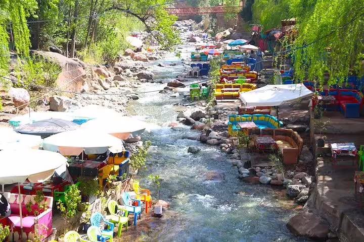 Ourika River lunch terraces with colorful tables, Atlas Mountains Ourika Valley day tour from Marrakech