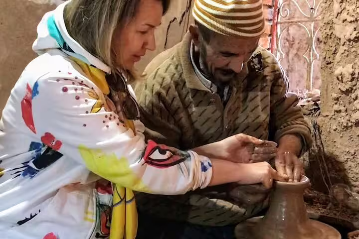 Traveler learning traditional pottery with local artisan on an Ourika Valley cultural tour from Marrakech