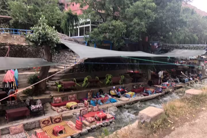Riverside cafes with colorful cushions along Ourika River, Atlas Mountains day trip to Ourika Valley from Marrakech
