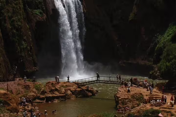 Ourika Valley waterfall in the Atlas Mountains with visitors on a footbridge, Marrakech day trip stop