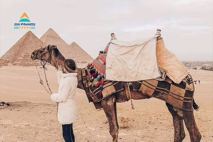 Camel and traveler at Giza Pyramids, Cairo stop on overnight VIP first class train tour from Luxor