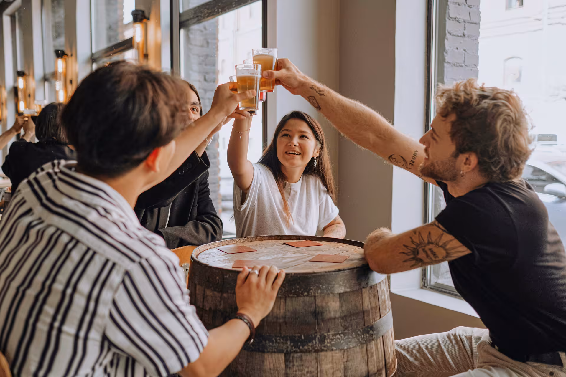 Group of friends joyfully toasting with cider at a cozy bar, capturing the essence of Oviedo's local culture.