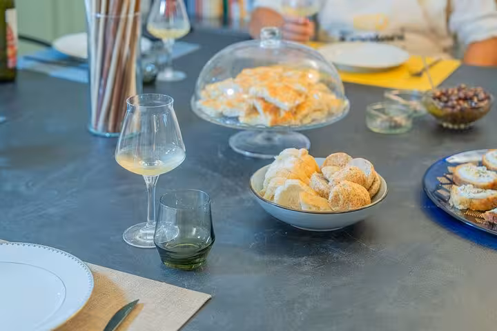 Elegant table setting with wine, assorted breads, and pastries, highlighting a refined Riviera tasting experience.