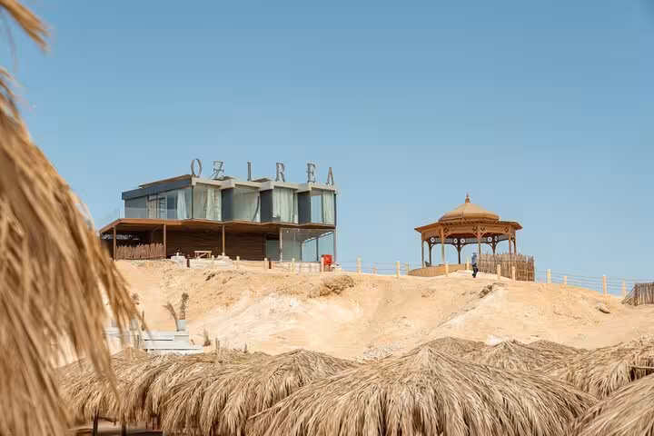 Ozirea Island beachfront with resort building and gazebo, a stop on private speedboat trip from Hurghada