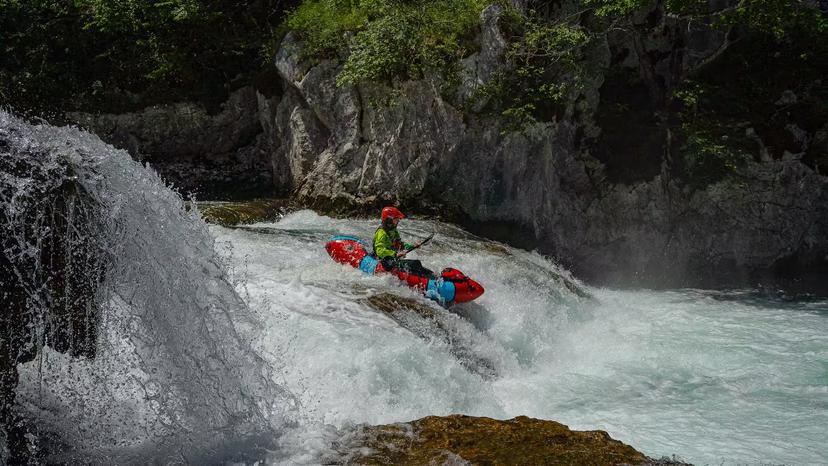 Packrafter tackling a waterfall descent on the thrilling Mreznica River adventure tour.