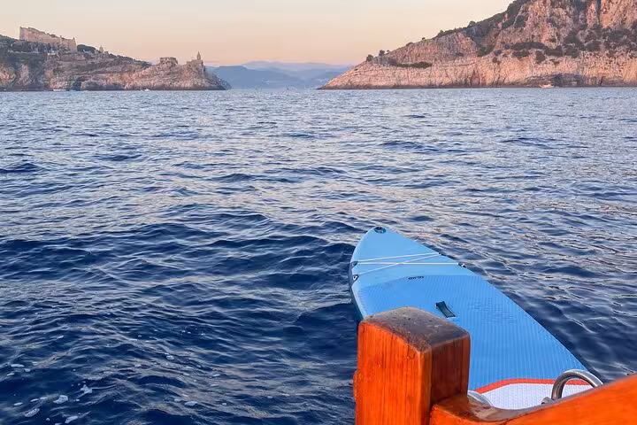 Paddleboard on tranquil waters with scenic view of La Spezia coastline, perfect for a dream boat tour.