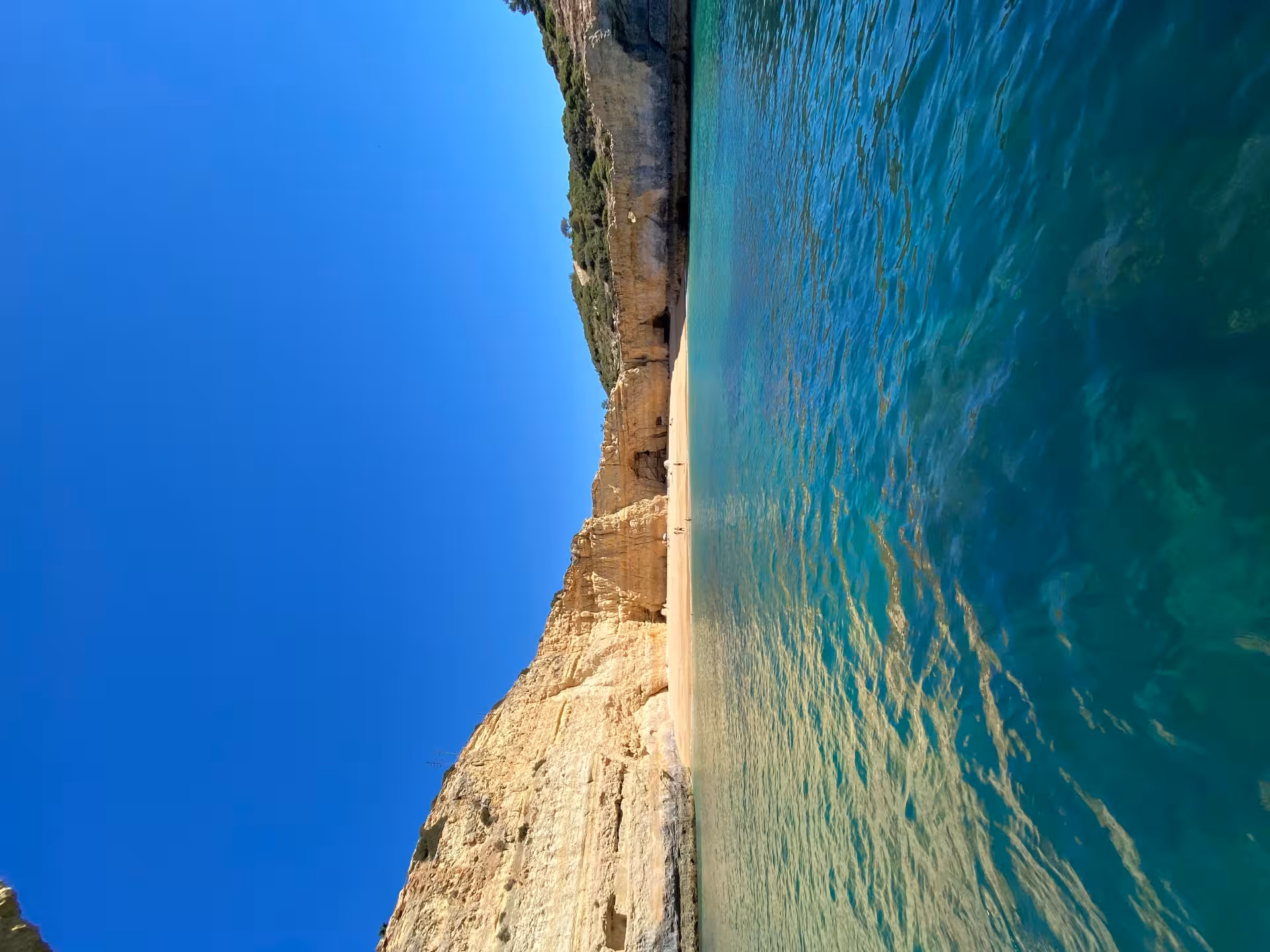 Hidden Algarve beach by Benagil caves at sunrise, towering limestone cliffs and crystal-clear turquoise Atlantic water