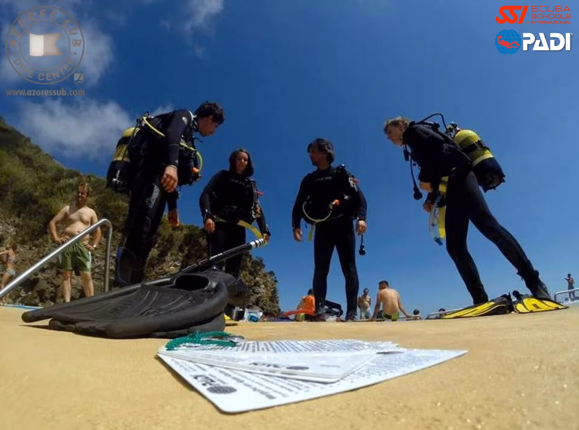 PADI Divemaster candidates gear up for shore dive briefing on São Miguel, Azores coast with scuba equipment