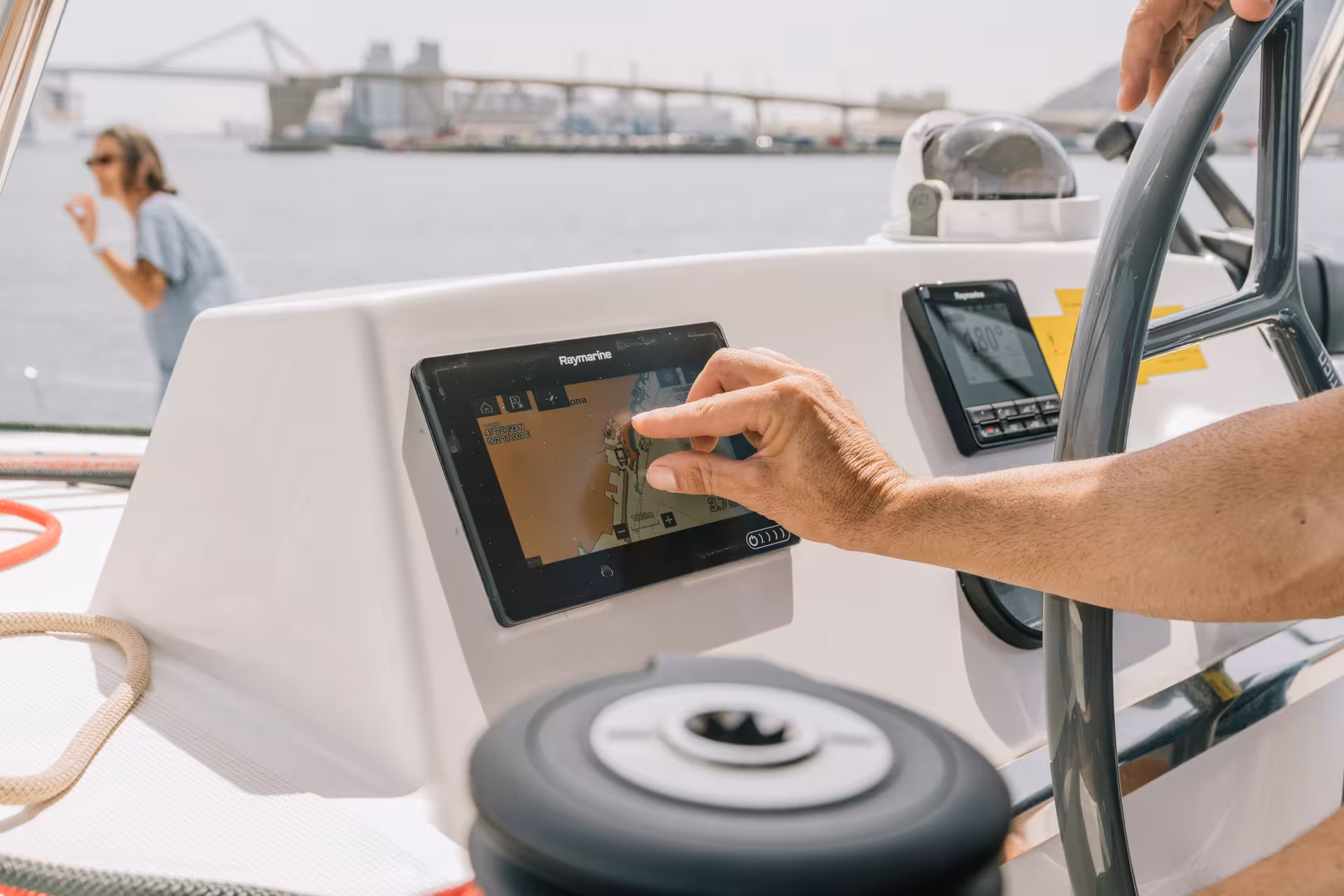 Chef navigating to the Paella Masterclass venue by boat, coastal views and marina in the background