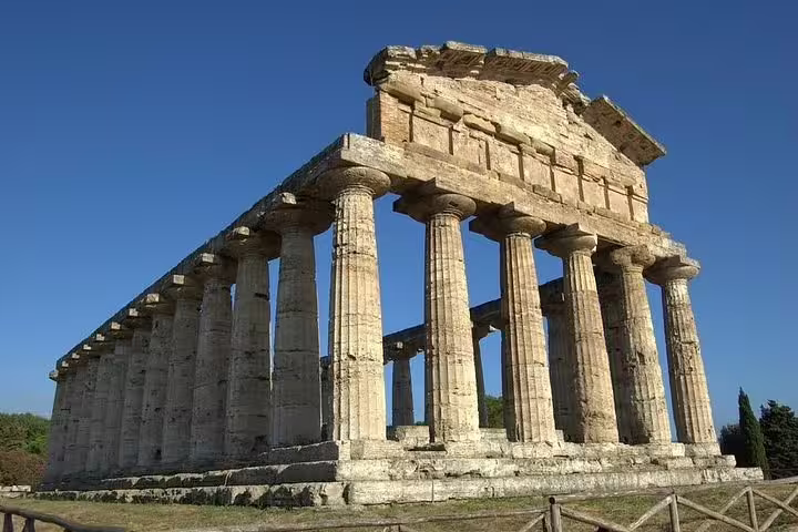 Side angle of monumental Paestum Greek temple ruins in Campania, Italy, showcasing stone columns on a private history tour