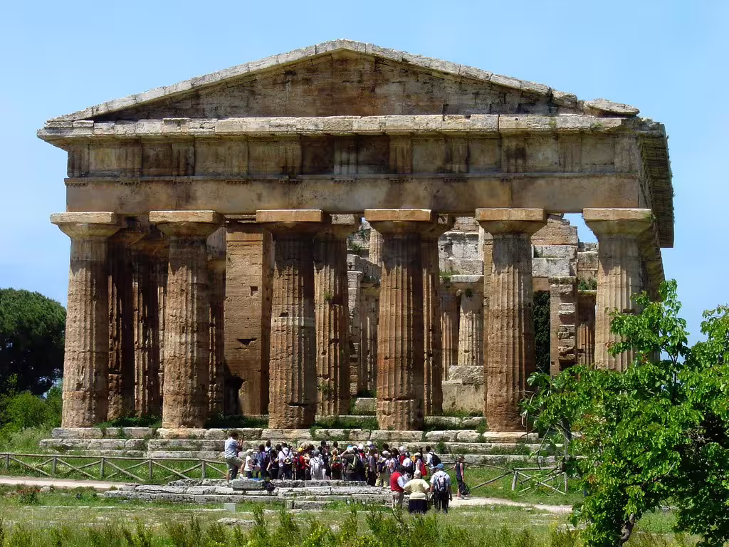 Guided group visiting the ancient Greek Temple of Hera in Paestum, Italy, on a sunny weekend cultural and culinary tour